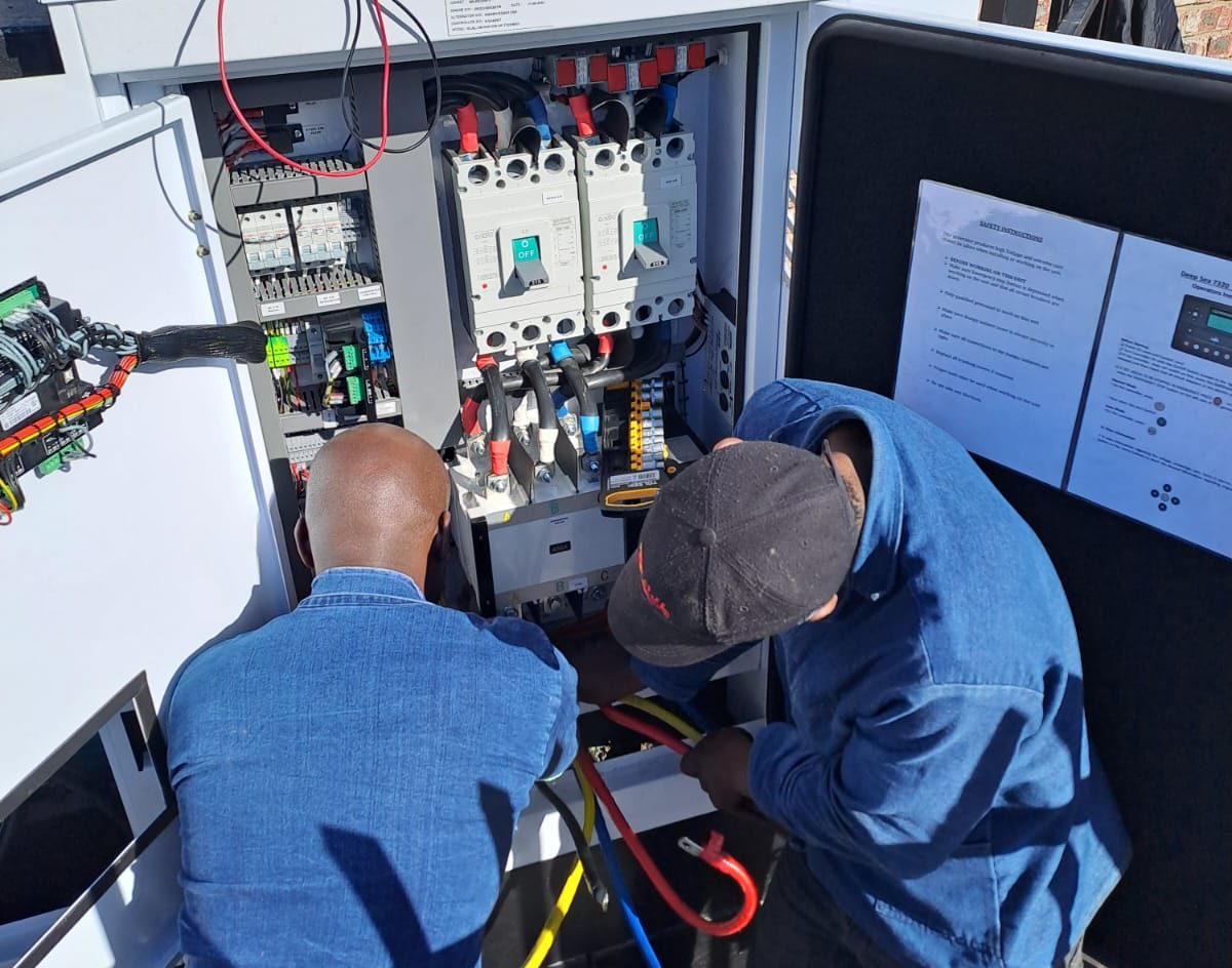 Electrical technicians working on a distribution panel