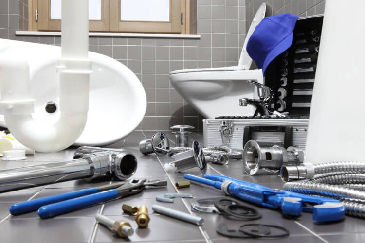 Plumbing tools laid out for a bathroom repair