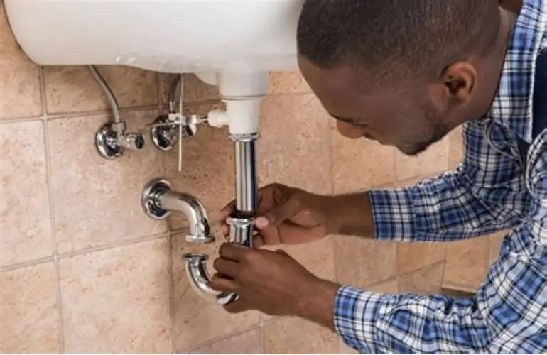 Plumber repairing pipework