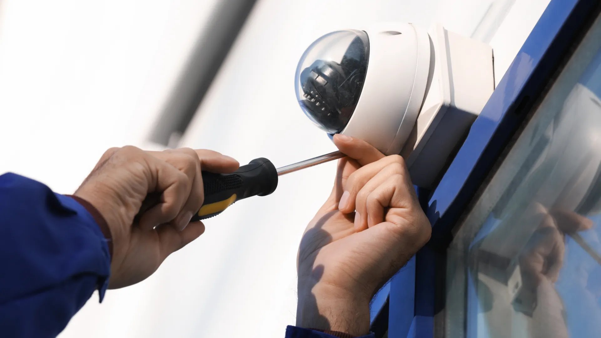 Technician installing a dome security camera